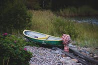 一艘充满活力的划艇停靠在岩石河畔，四周被大自然和鲜花环绕