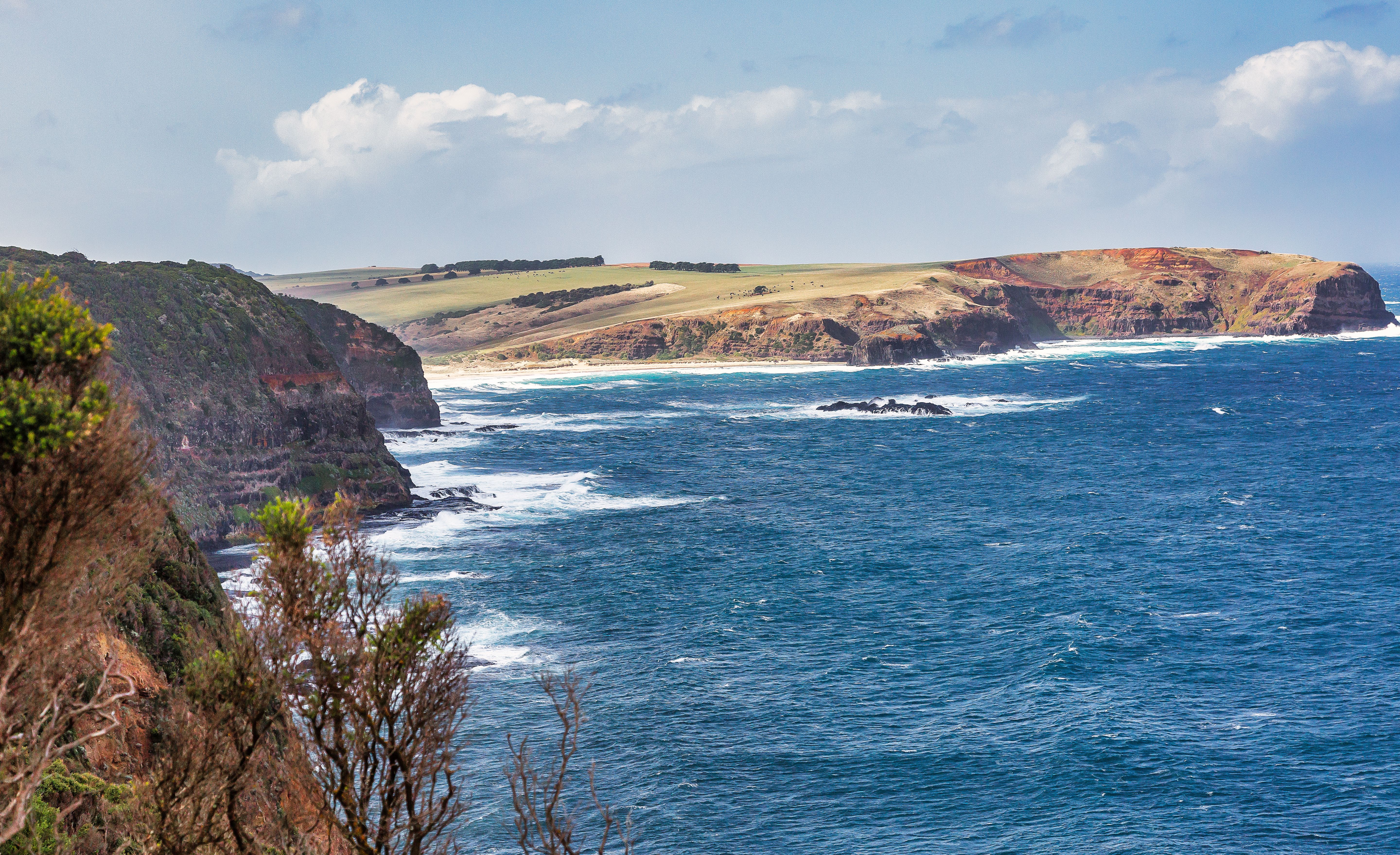 A stunning scene of rocky coastal cliffs along a vibrant blue ocean, perfect for travel and nature lovers.