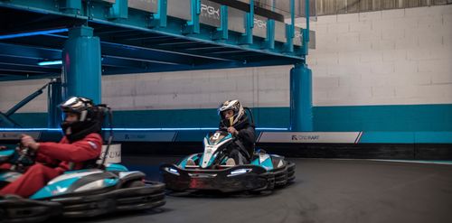 Free Dynamic indoor go-kart racing with two drivers competing on the track. Stock Photo