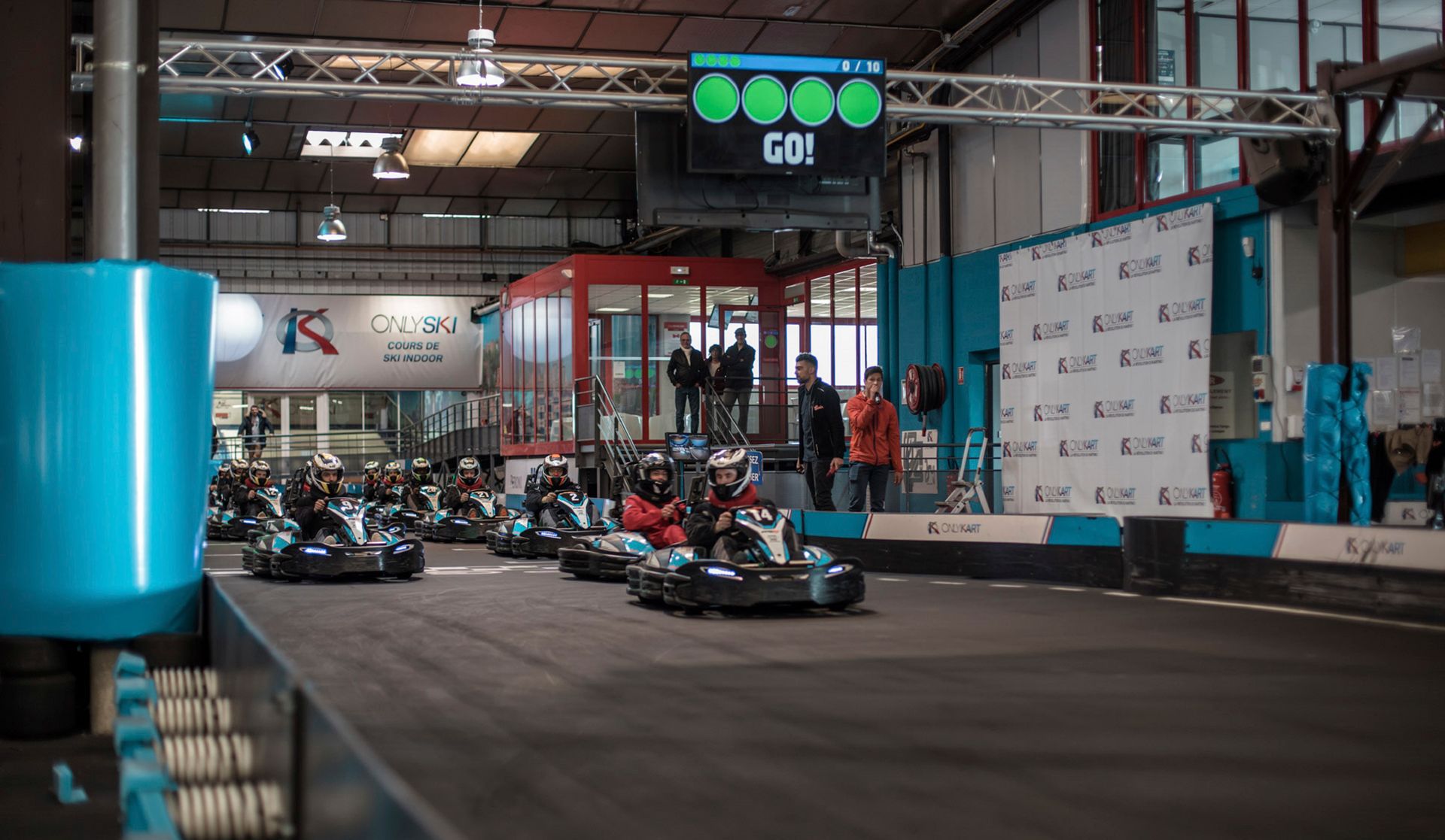 Exciting indoor go-kart racing event at the starting line with racers ready to speed off.