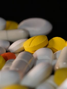 Close-up of various colored pills and capsules against a dark backdrop.