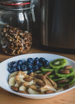 A vibrant bowl featuring fresh fruit slices, nuts, and peanut butter for a nutritious breakfast.