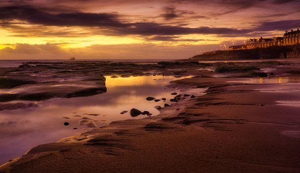 Stunning golden hour beachfront with reflective waters at dusk, perfect for serene landscapes.