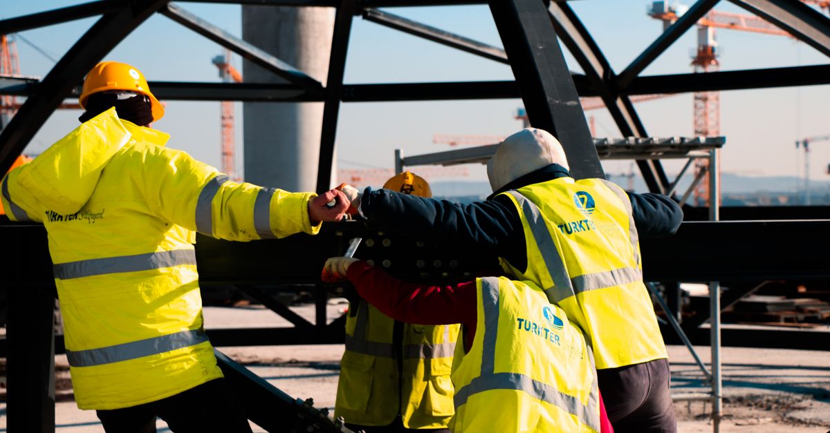 Construction team in Türkiye working on steel framework, showcasing safety and teamwork.