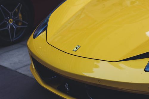 Free Close-up of a sleek yellow Ferrari sports car, showcasing luxury automotive design. Stock Photo