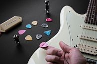 Electric Guitar and Plectrums on Black Surface