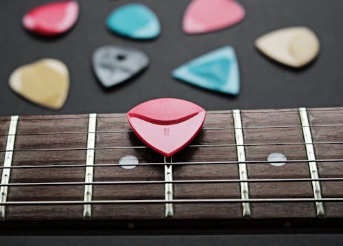 Close-Up Shot of a Guitar Pick on a Fretboard