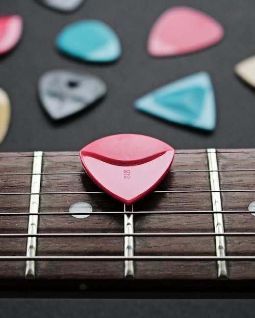 Close-Up Shot of a Guitar Pick on a Fretboard