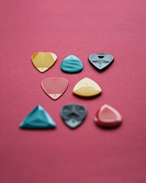 Close-Up Shot of Guitar Picks on a Pink Surface