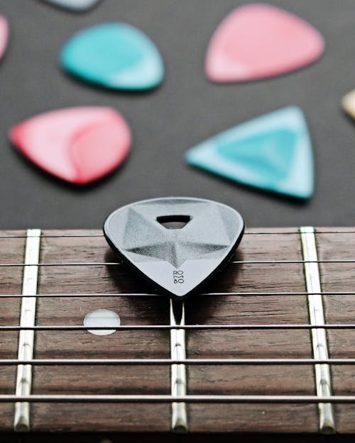 Close-Up Shot of a Guitar Pick on a Fretboard