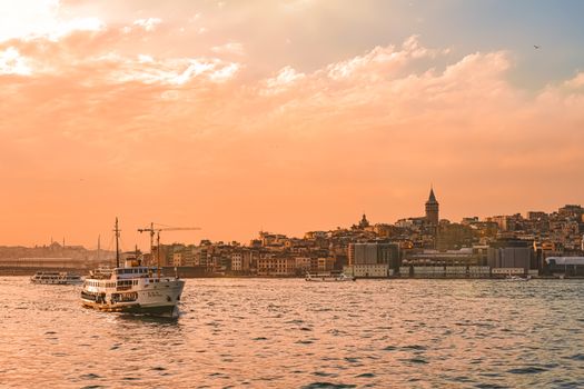 Beautiful view of Istanbul's skyline and ferry during a vibrant sunset over the Bosphorus.