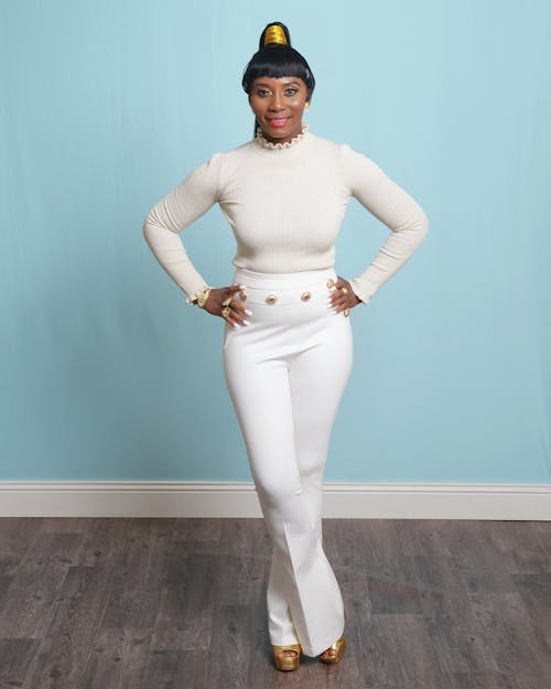 A Woman in White Long Sleeves and Pants Standing with Her Hands on Her Waist