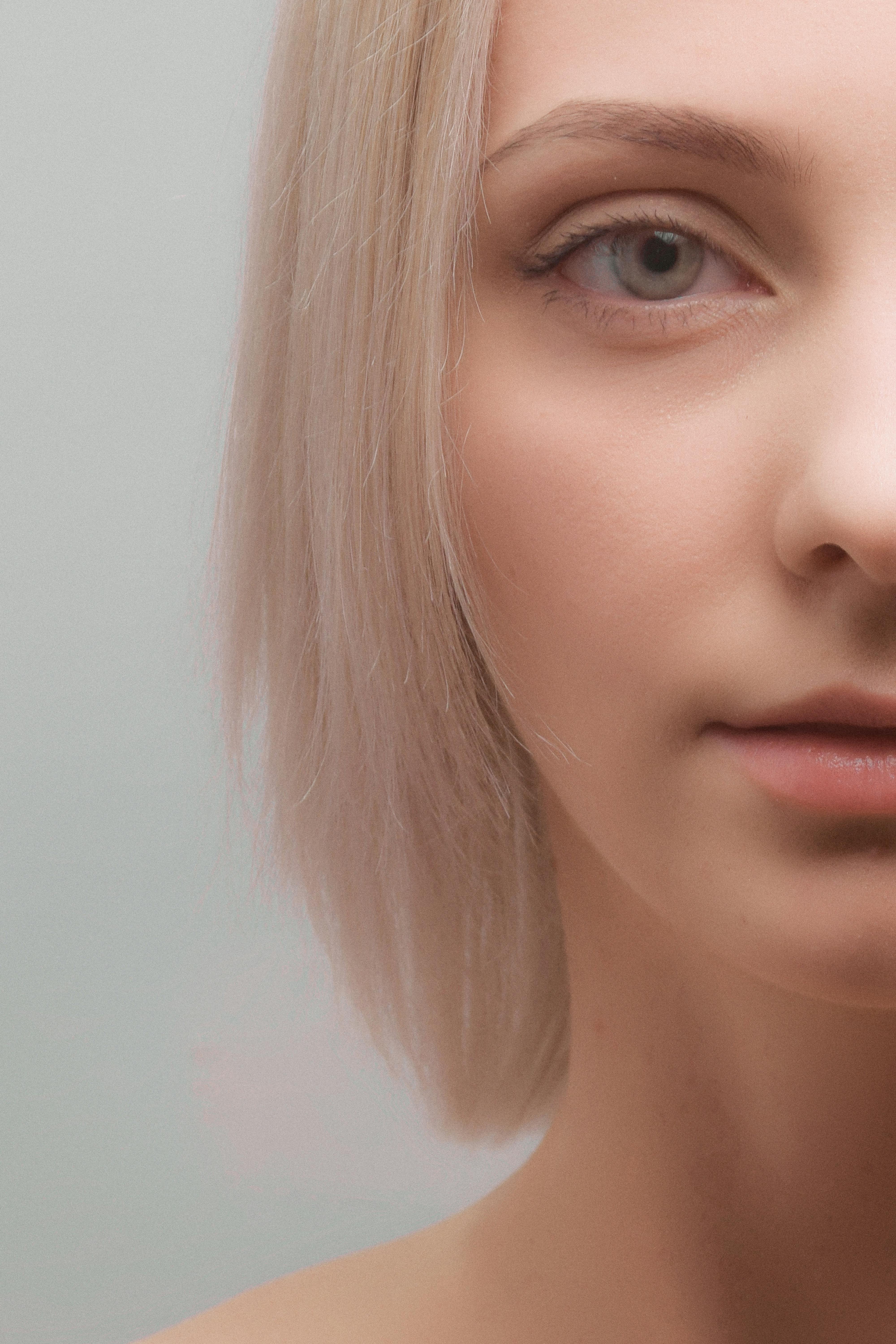 Artistic close-up portrait of a woman with striking blonde hair. Studio photography.