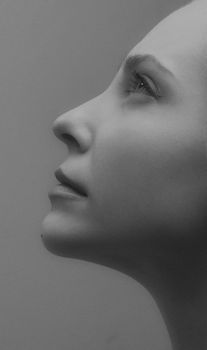 Monochrome side profile portrait of a woman looking upwards with a serene expression.
