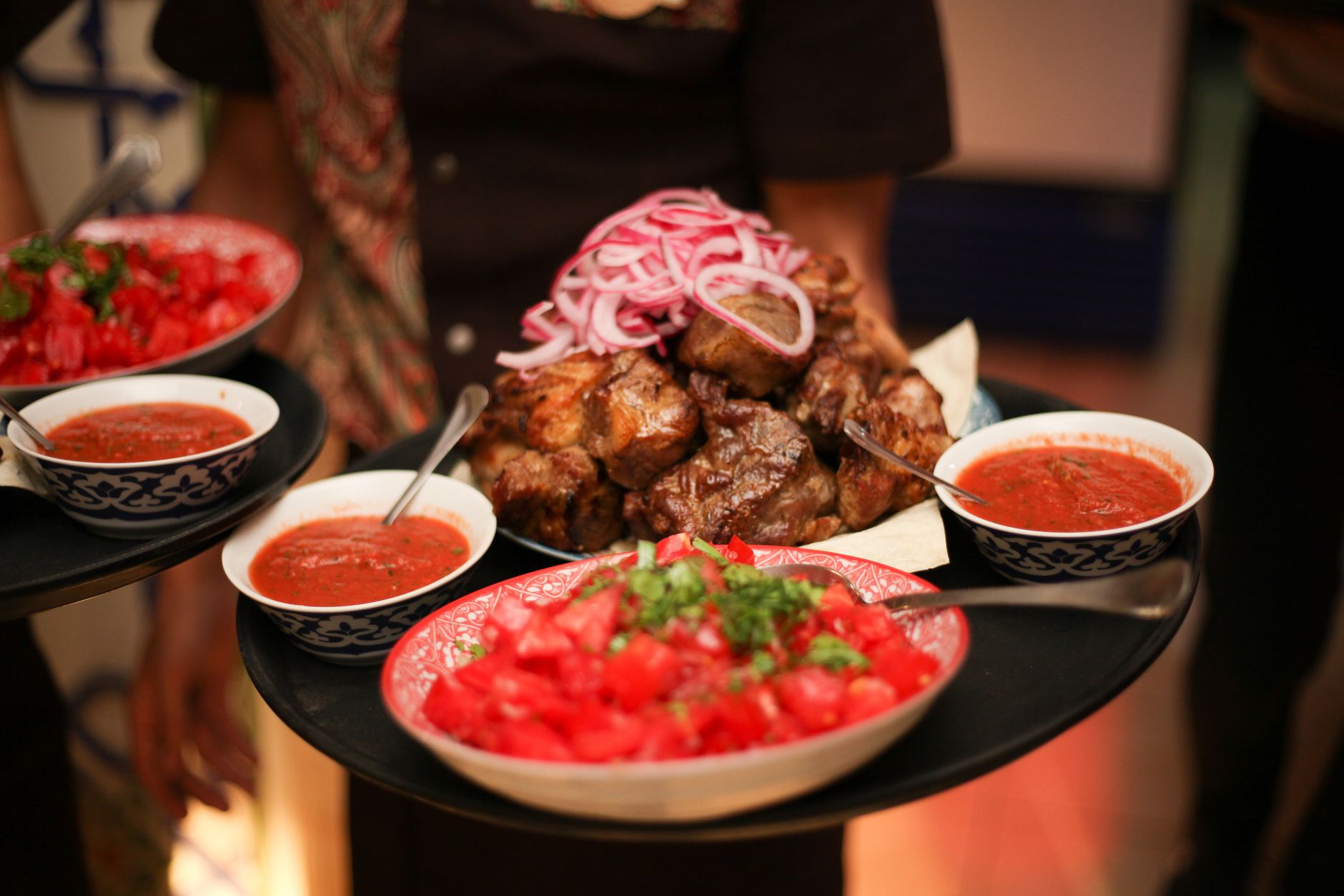 Mouthwatering platter featuring grilled meat with fresh salsa and spicy sauces, offering a delightful dining experience.