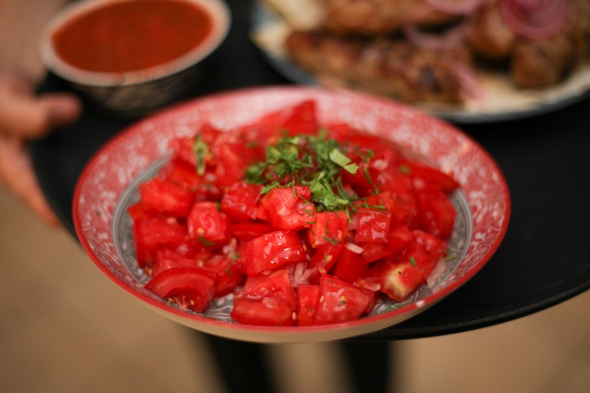 Salade de tomates fraîches aux herbes servie dans un saladier décoratif