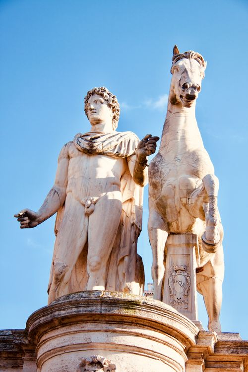 Free Majestic statue of a man with a horse under a clear blue sky in Rome, Italy. Stock Photo