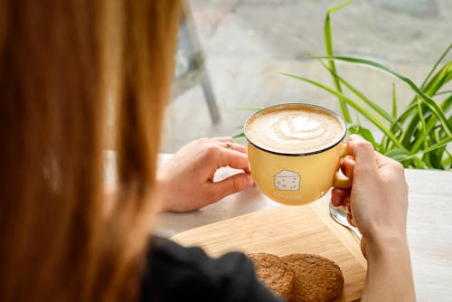 Person Holding Yellow Ceramic Mug With Coffee