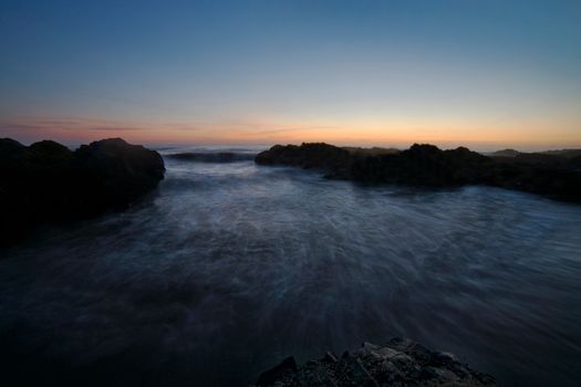 Peaceful sunset over the ocean at Yachats, Oregon, with gentle waves and a scenic horizon.