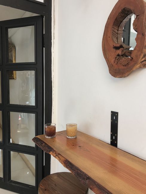 Two glasses of coffee on a rustic wooden table in a modern Turkish cafe setting.