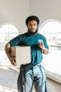 Man in Blue Crew Neck T-shirt and Black Pants Holding White Paper