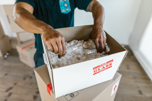 Free A Person Putting the Glasses in a Box Stock Photo