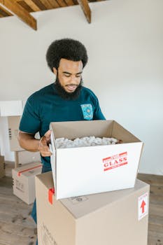 African American man packing boxes indoors, preparing for moving day.