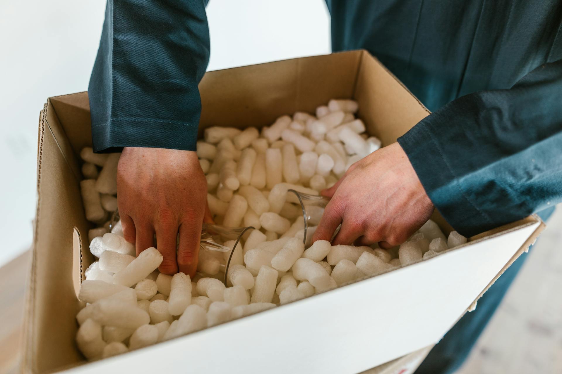 A Person Putting the Glasses in a Box Full of Polystyrene Foam