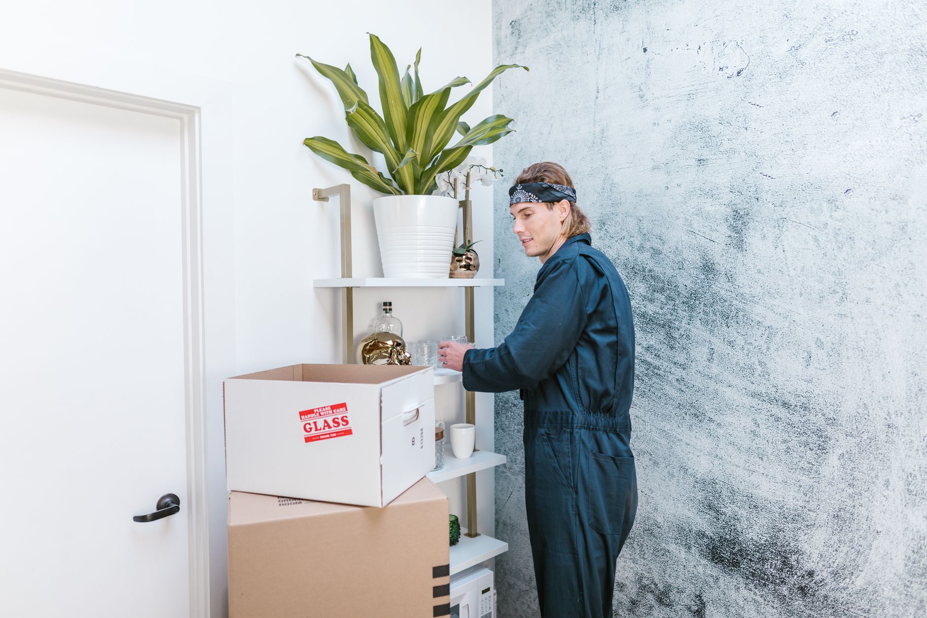 warehouse worker packing fragile glass items into reinforced cardboard boxes