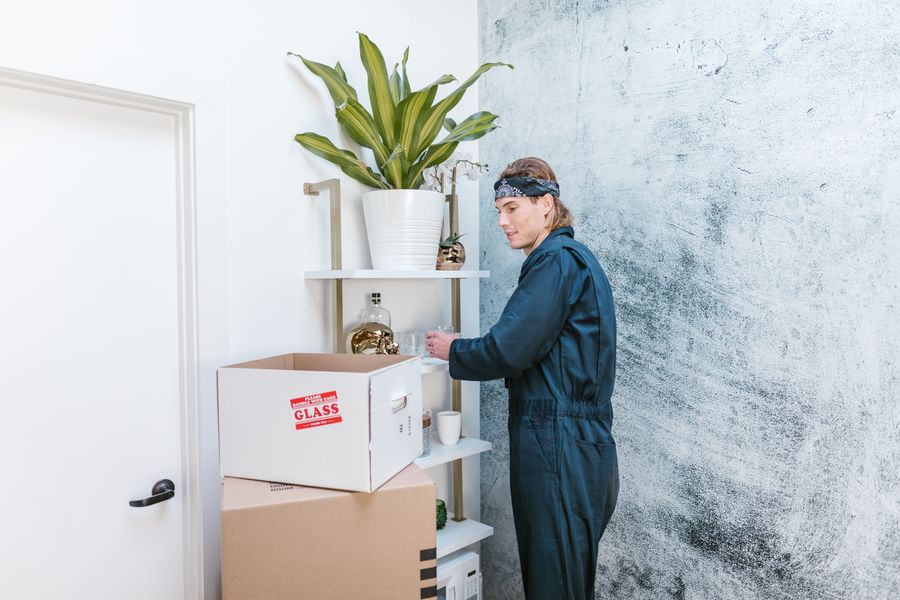 Boxwell mover arranging furniture and boxes in a customer's new home