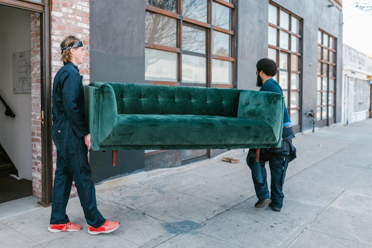 Close-Up Shot Of Men Carrying A Couch