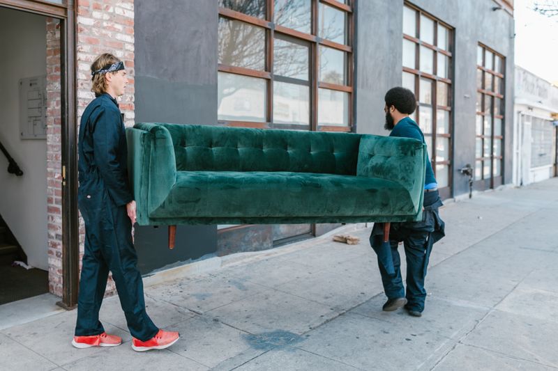 SwiftHaul Moving professional wrapping a sofa inside a Philadelphia home