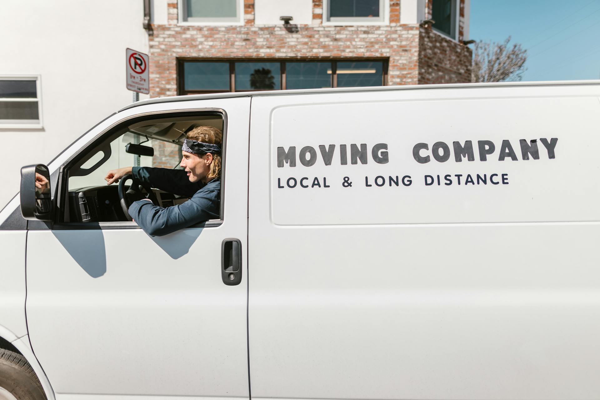 Driver in a moving company's van providing local and long-distance services.