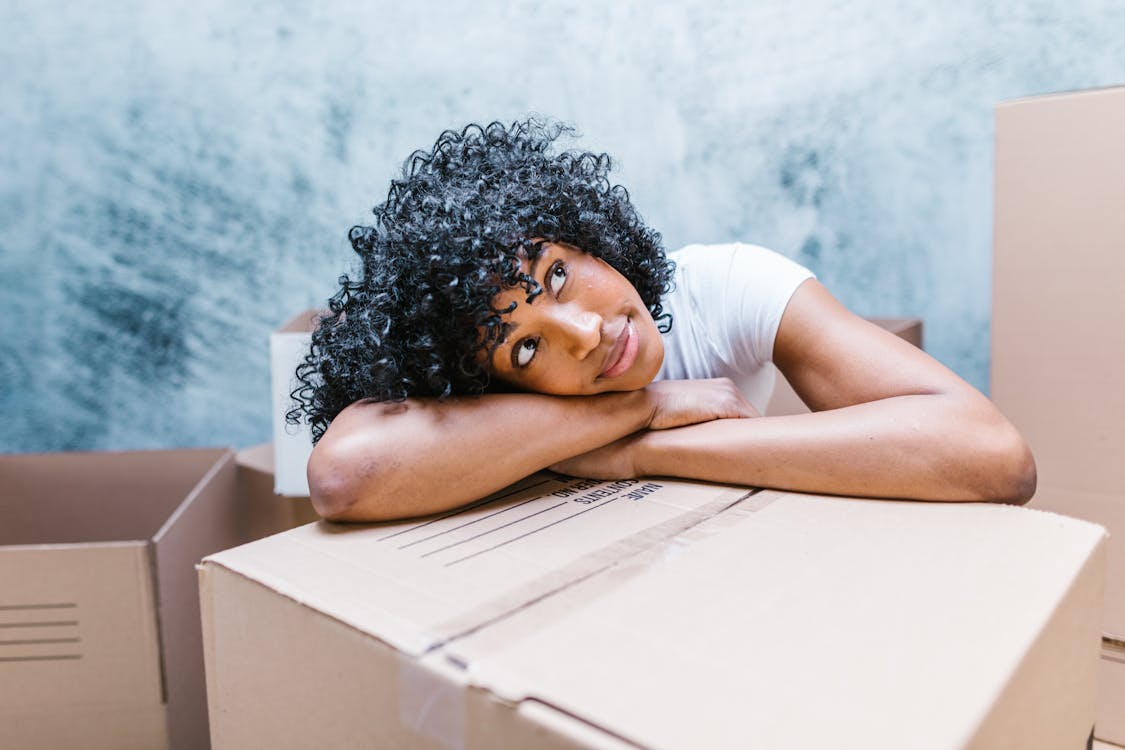 A Woman Resting Her Head on a Cardboard Box