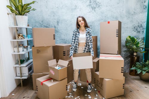 A Woman in a Plaid Long Sleeves Carrying a Box