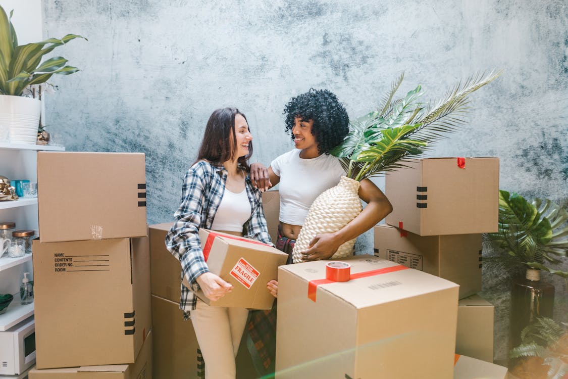 Free 2 Women Surrounded by Boxes Stock Photo