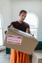 Man in Black Crew Neck T-shirt Holding Brown Cardboard Box