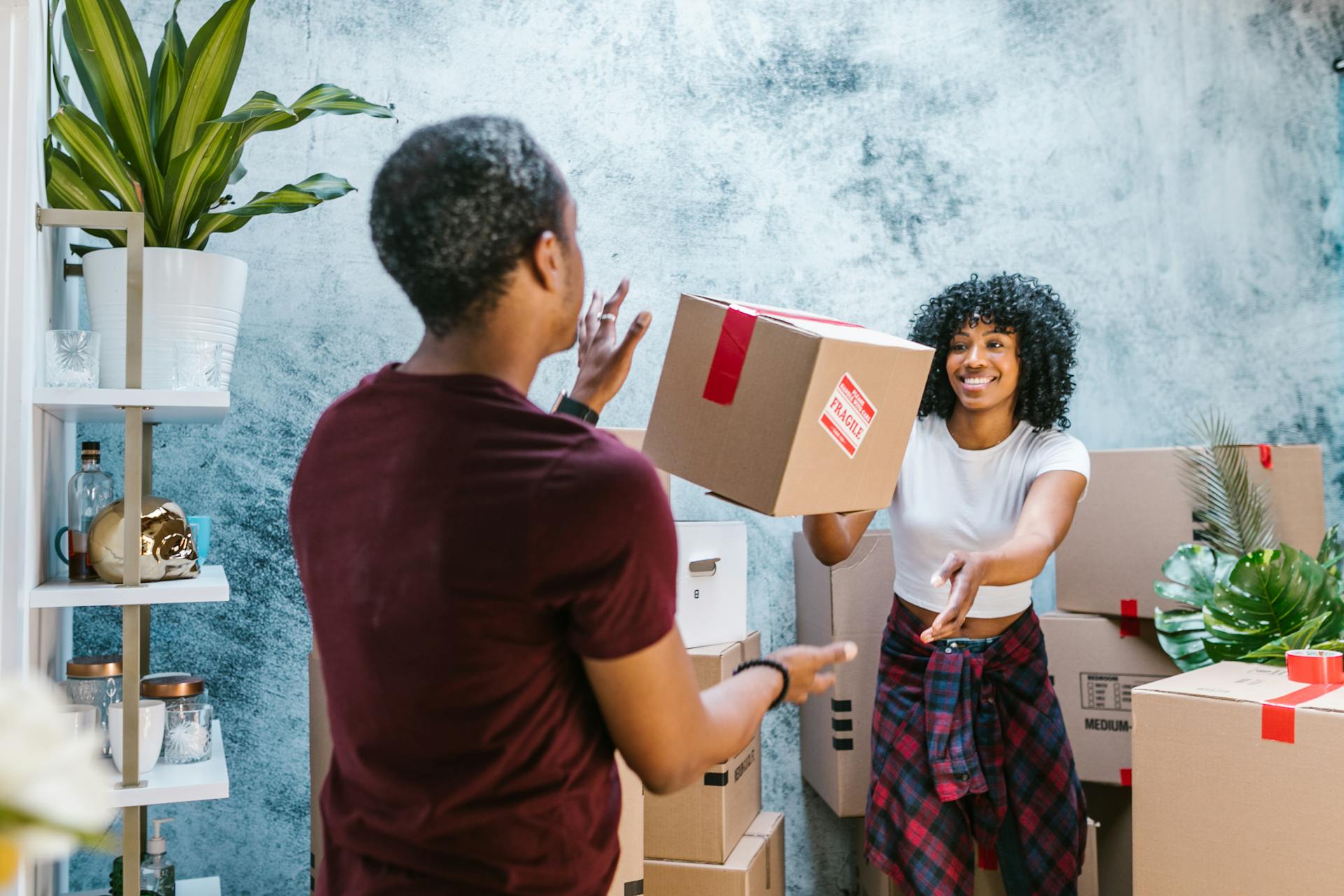 Woman Throwing Moving Box to Friend