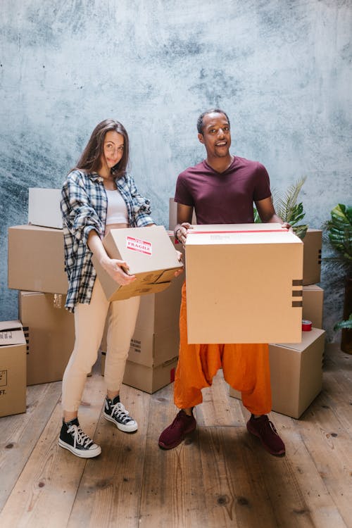 Free Man and Woman Holding Cardboard Boxes Stock Photo