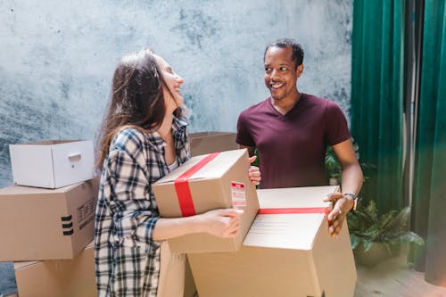 Free Man and Woman Carrying the Moving Boxes  Stock Photo