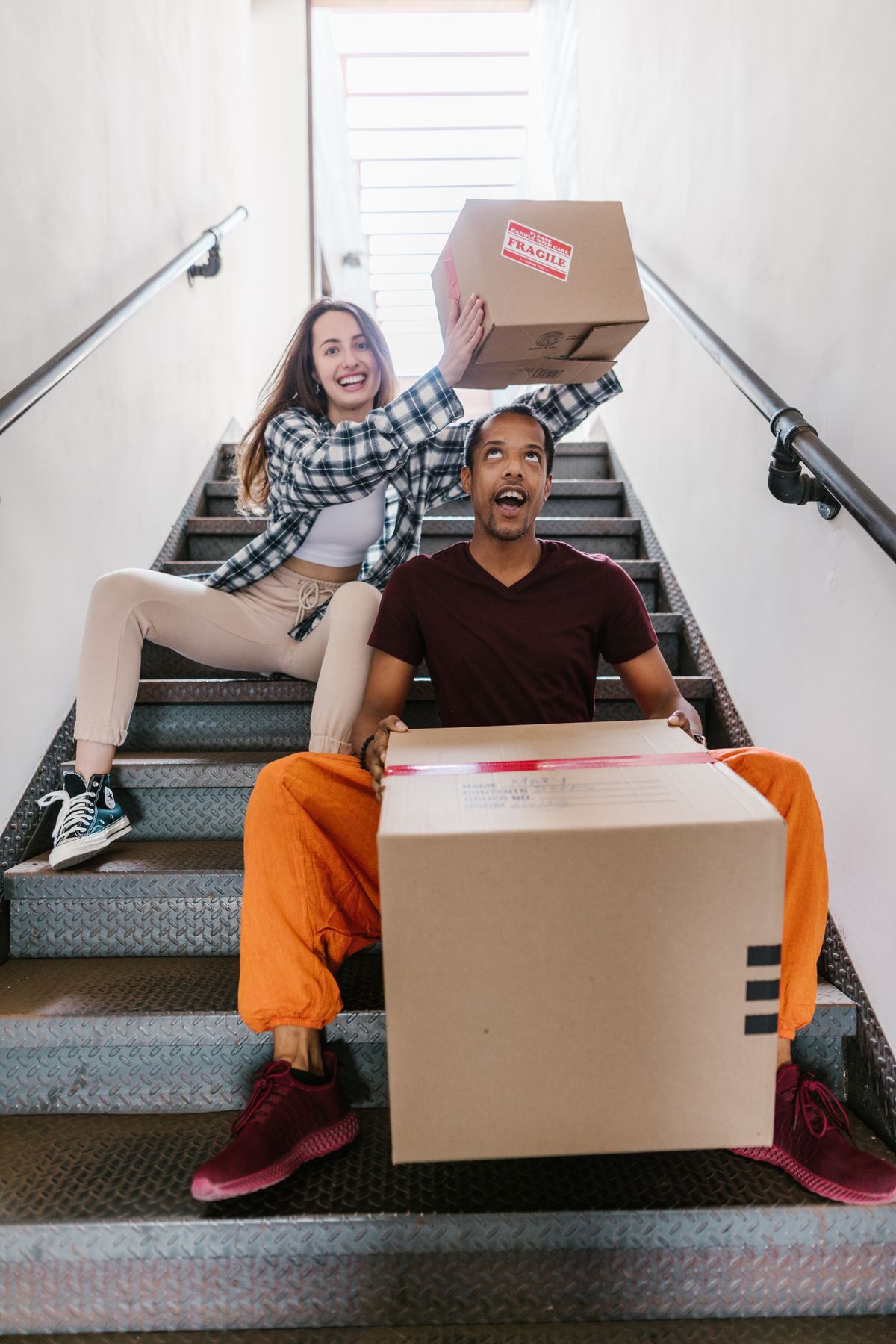 Couple carrying moving boxes into their new home
