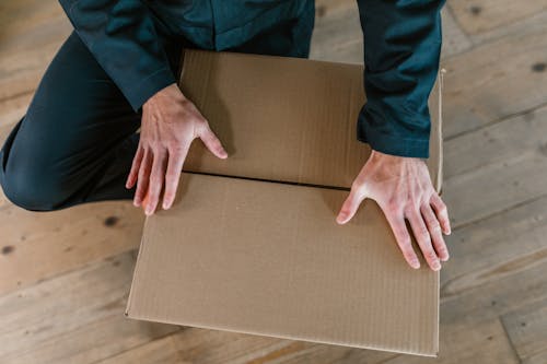 Close-Up Shot of a Person Holding a Cardboard Box