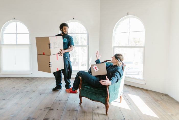 Mover carrying boxes into a new home