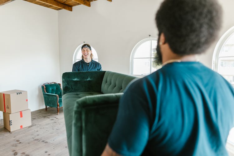 Close-Up Shot Of Men Carrying A Couch