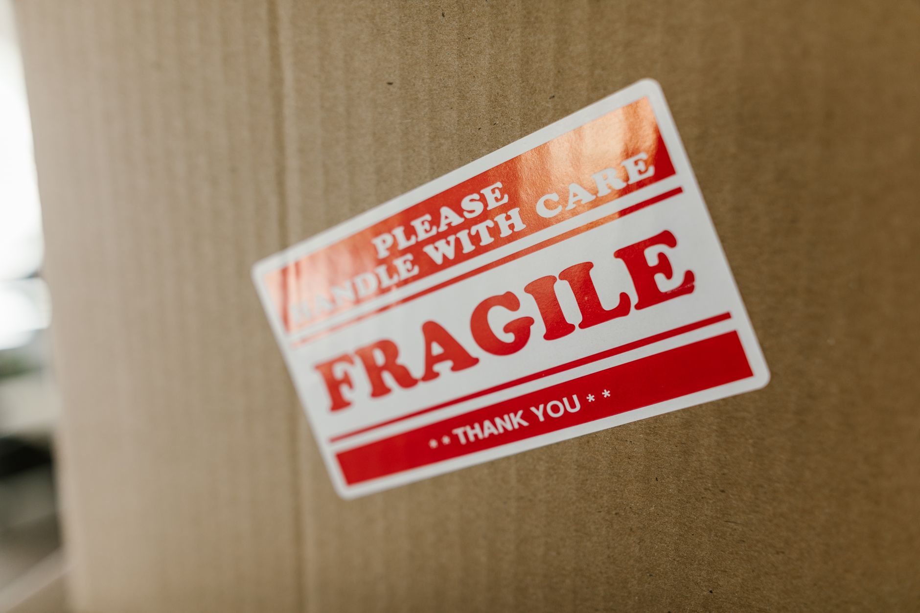 fragile parcel wrapped with minimal packaging on a warehouse table