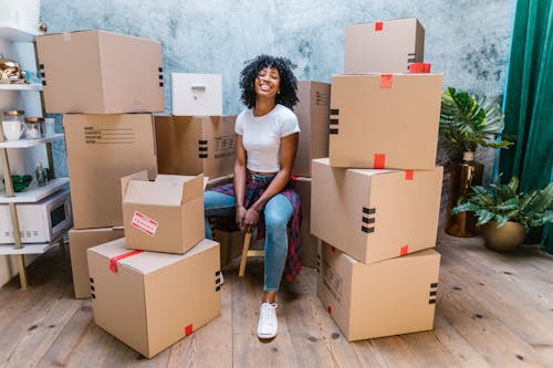 Free Photograph of a Woman in a White Shirt Sitting Beside Cardboard Boxes Stock Photo