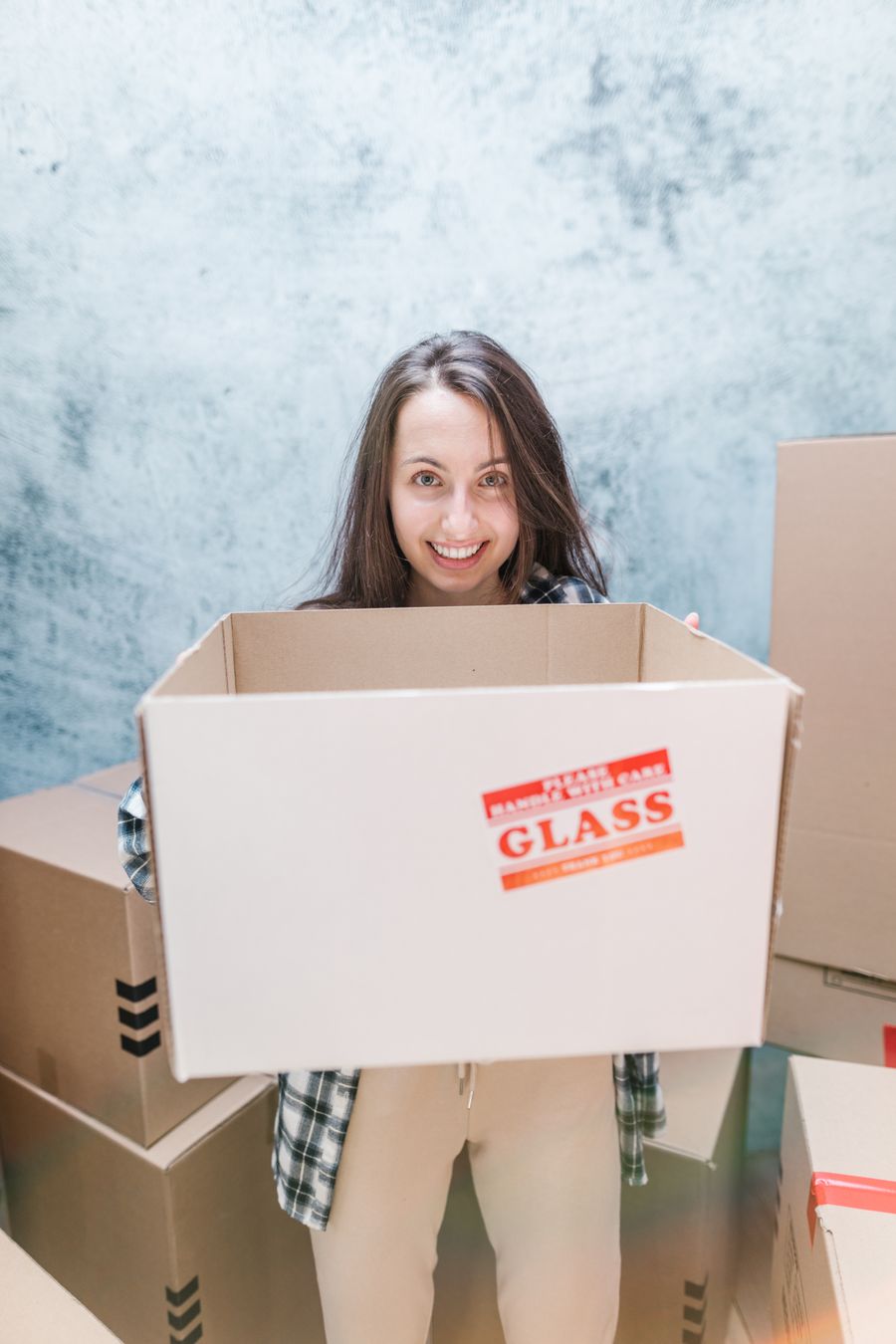 Cliente souriante tenant un carton fragile