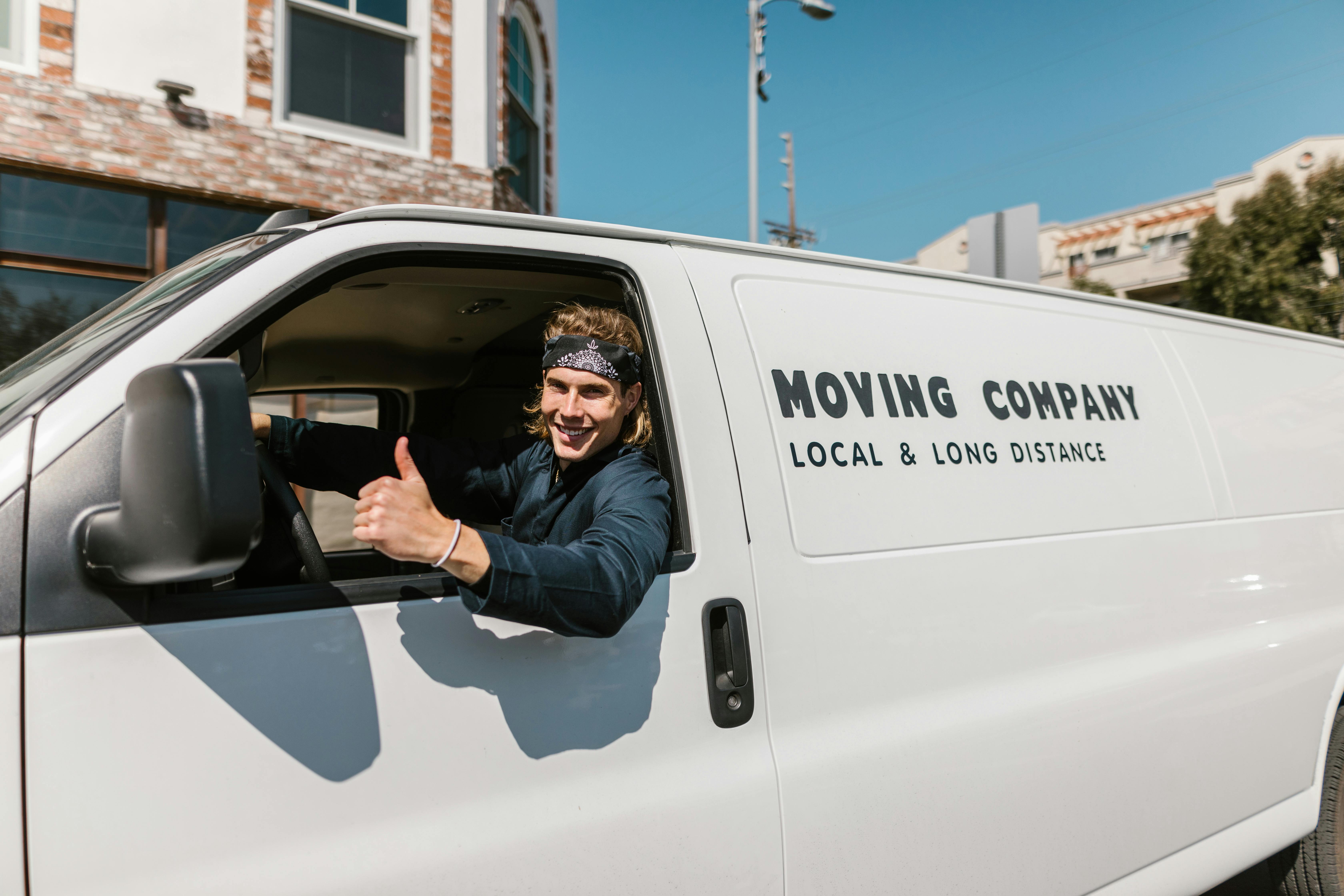 man in black jacket and black pants sitting on white van