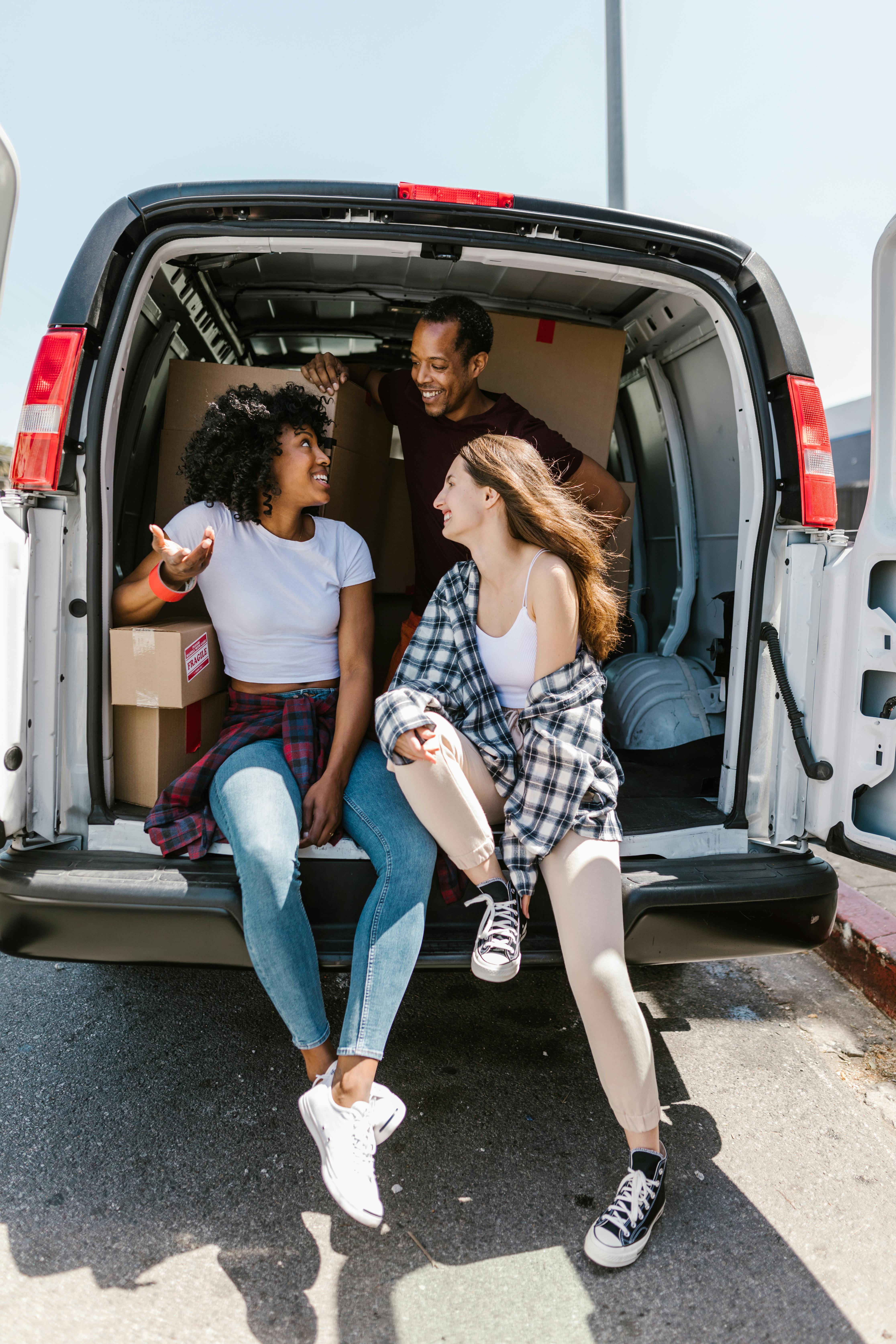 man and woman sitting on white van