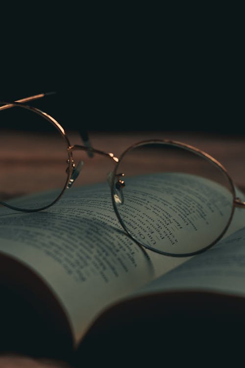 Photo of Eyeglasses on Top of an Open Book